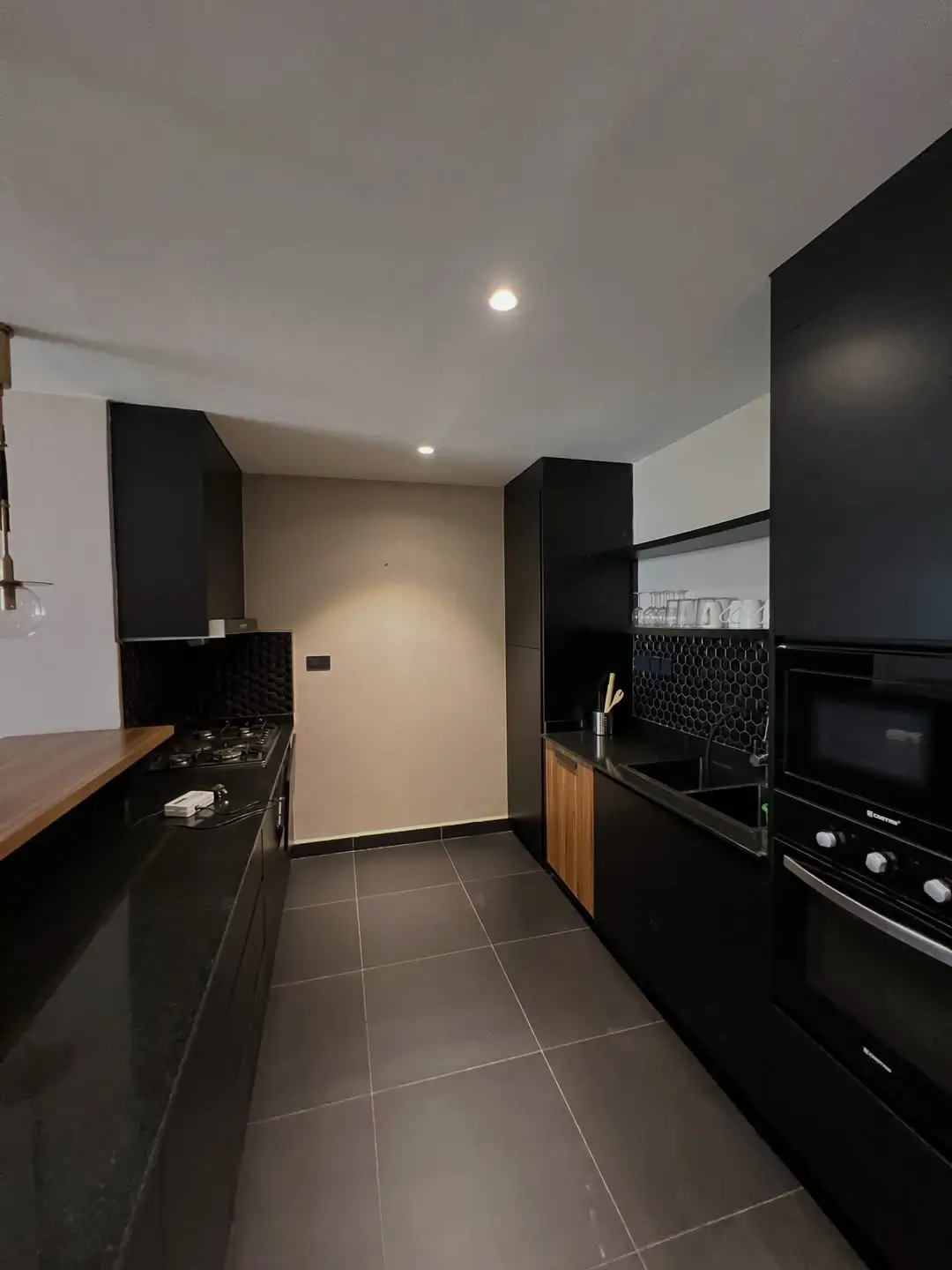 Modern galley kitchen with black cabinetry and integrated appliances