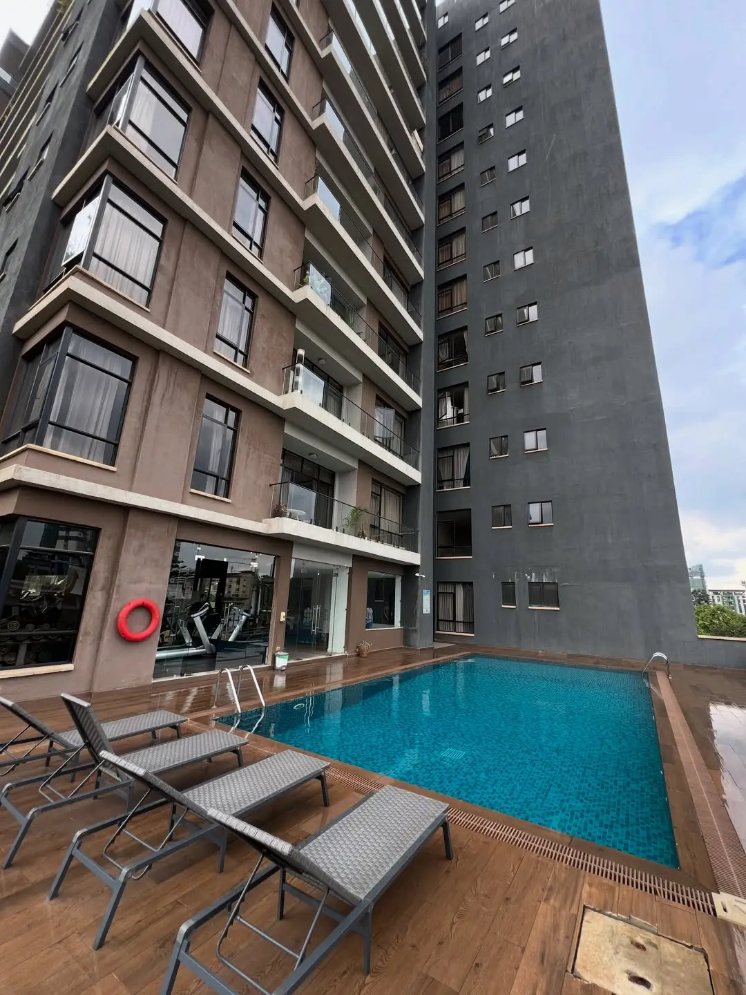 Rooftop swimming pool with loungers and building facade