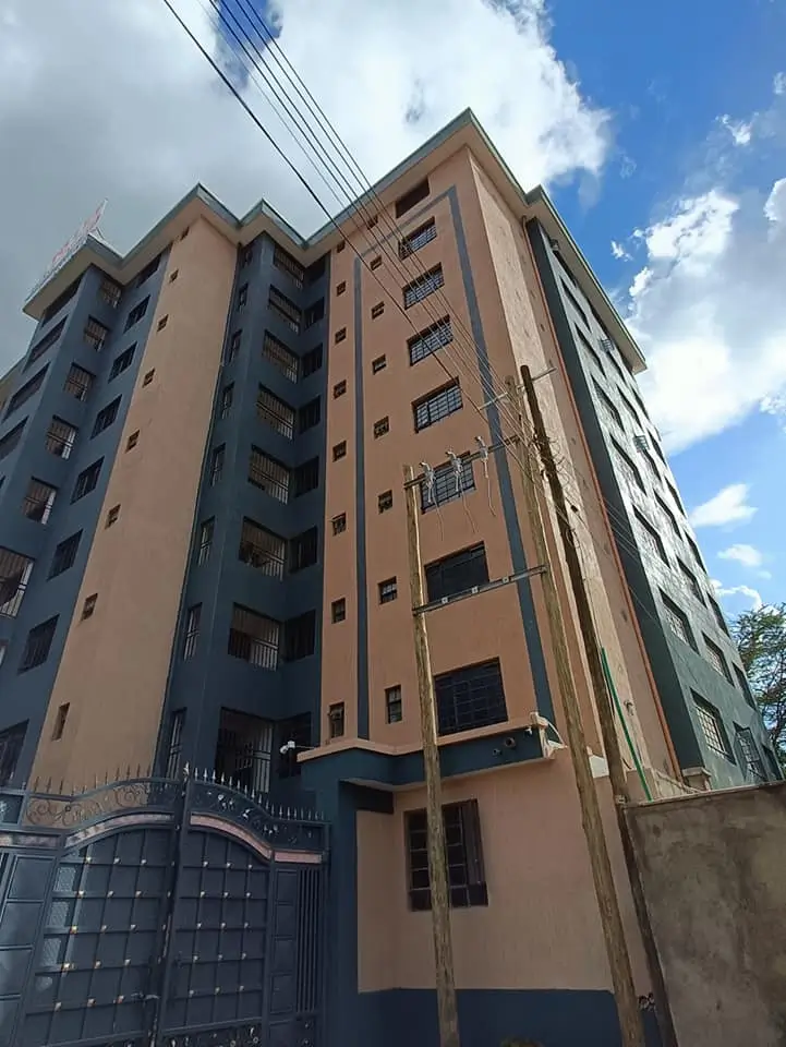 Multi-story residential building facade with blue metal gate