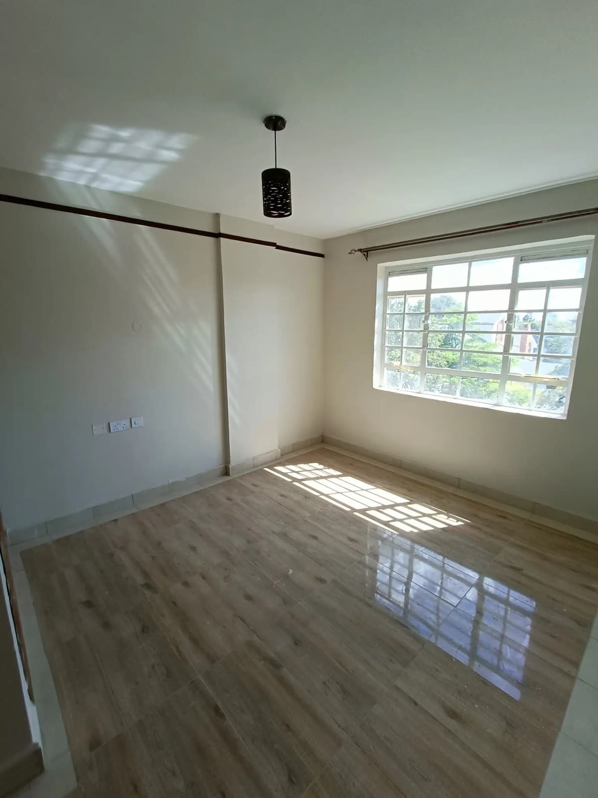 Bright bedroom with wooden flooring and large windows
