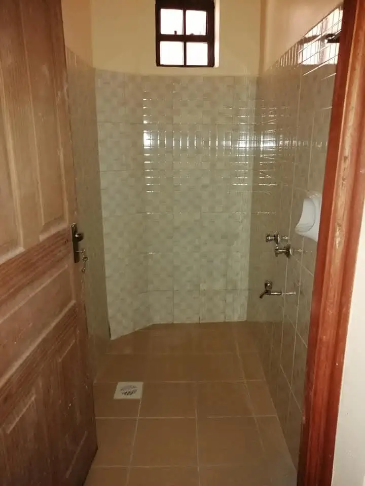 Shower room with tiled walls and brown floor