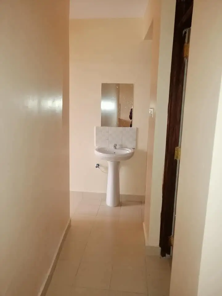 Compact bathroom with pedestal sink and mirror