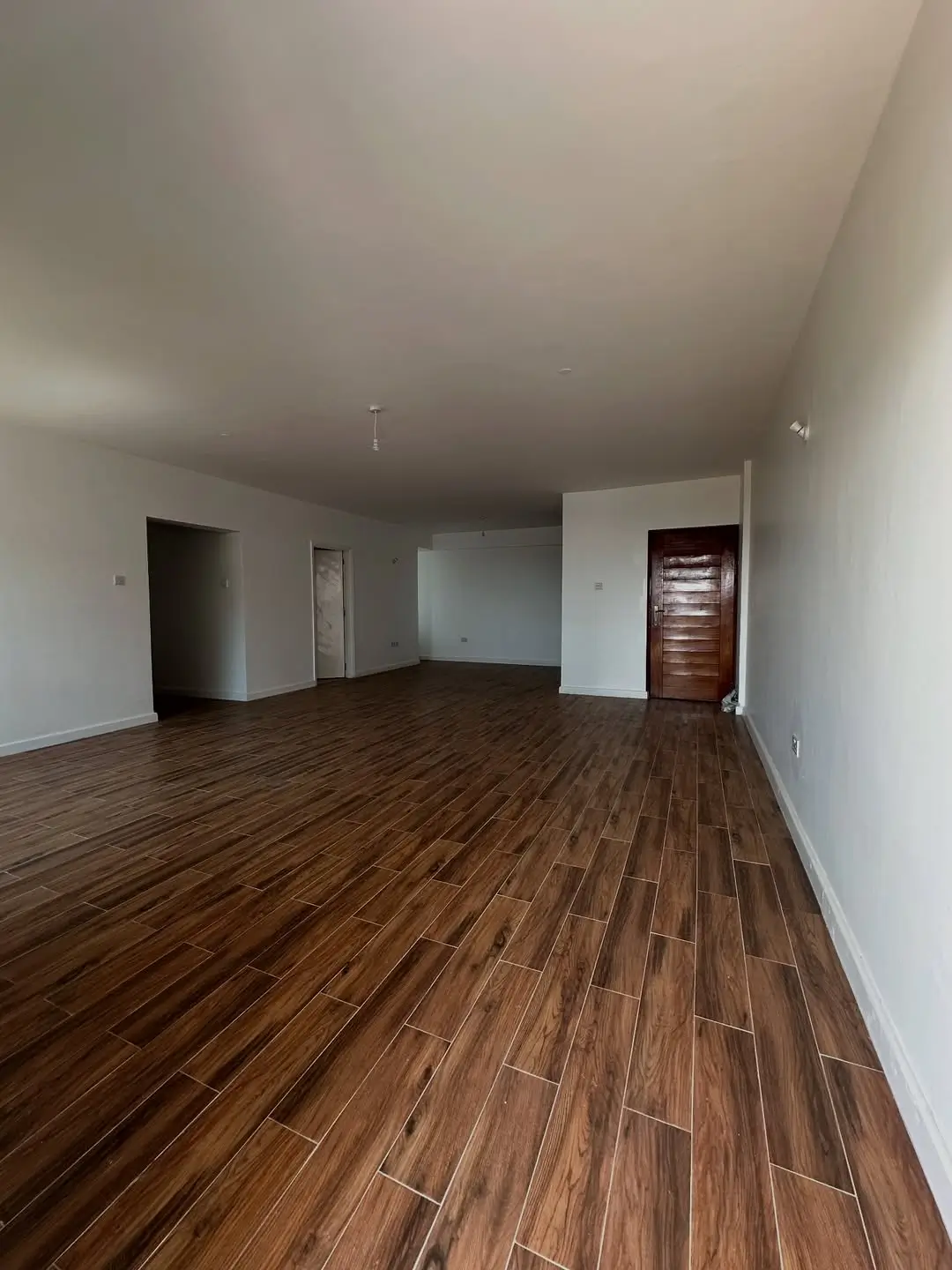 Spacious open-plan living area with wood-effect flooring