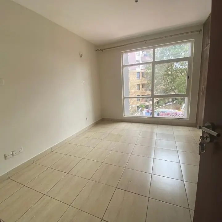 Bright bedroom with large window overlooking city street