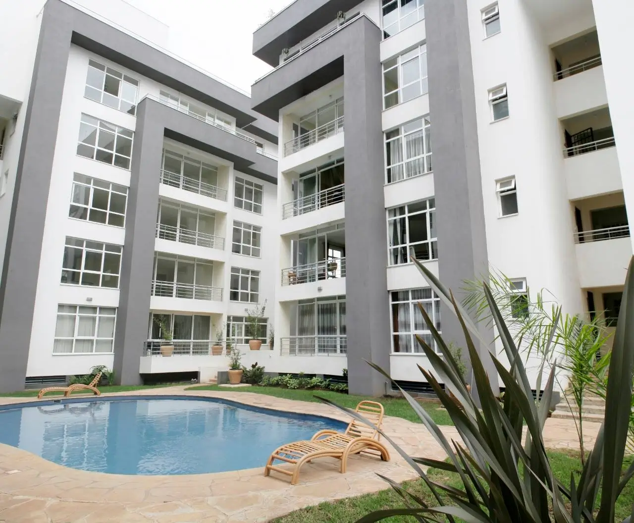 Resort-style pool with loungers in apartment courtyard