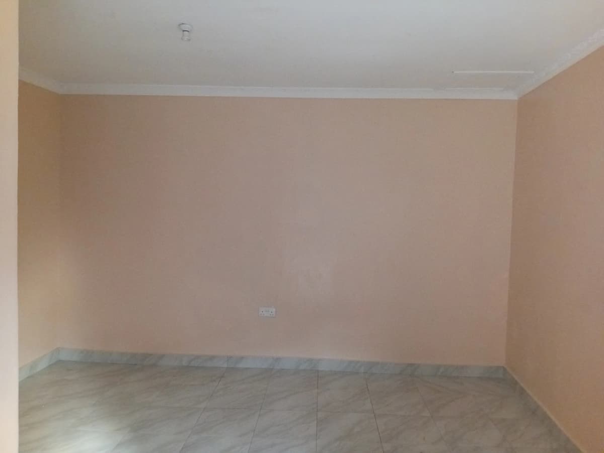 Empty bedroom with peach walls and concrete floor