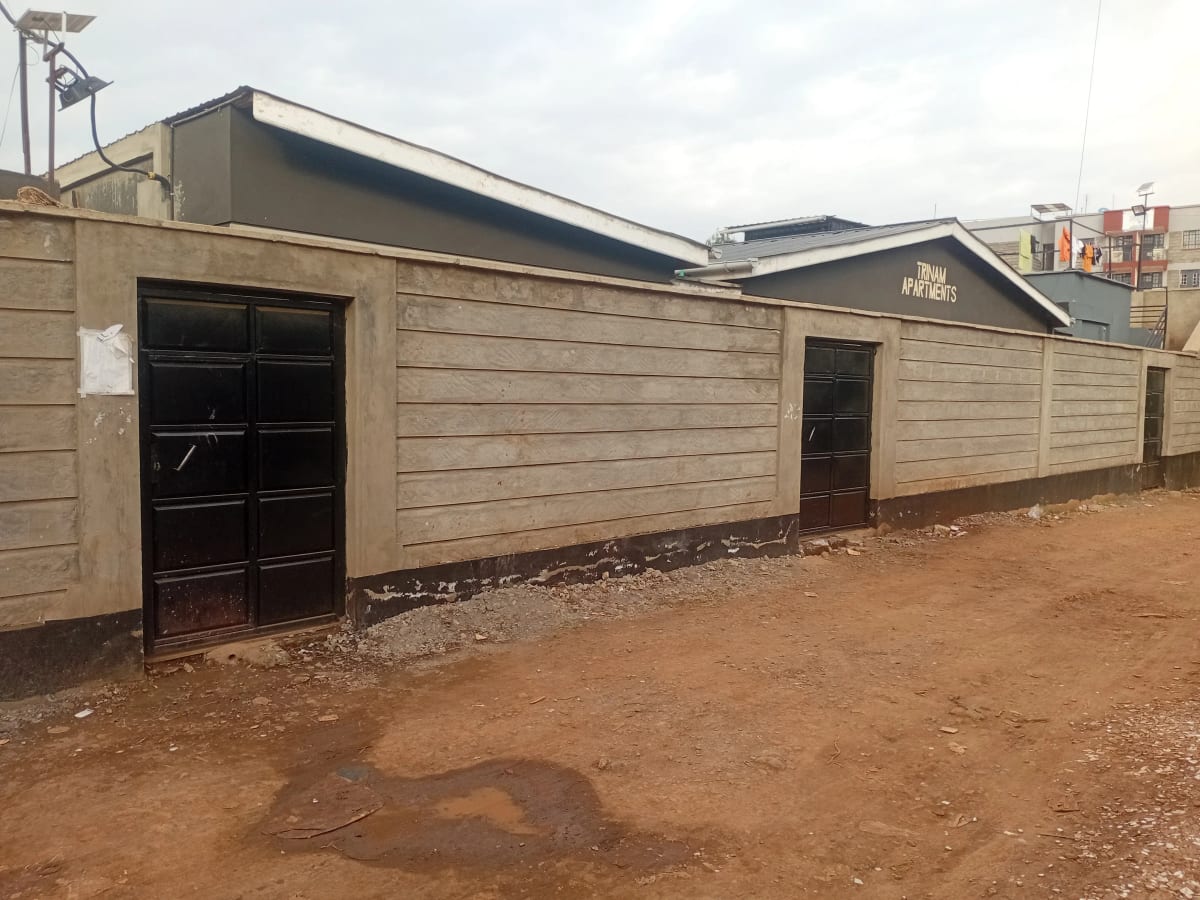 Beige residential structure with black metal doors and gates