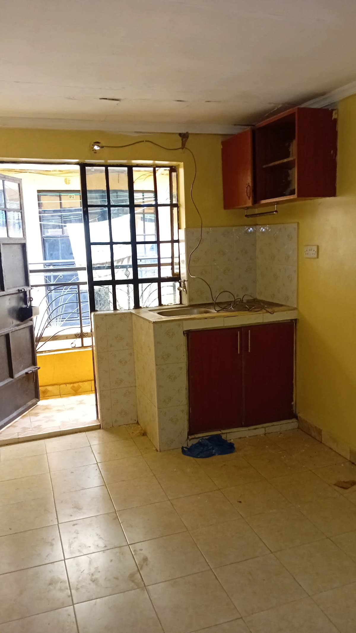 Compact kitchen with red cabinets and yellow walls