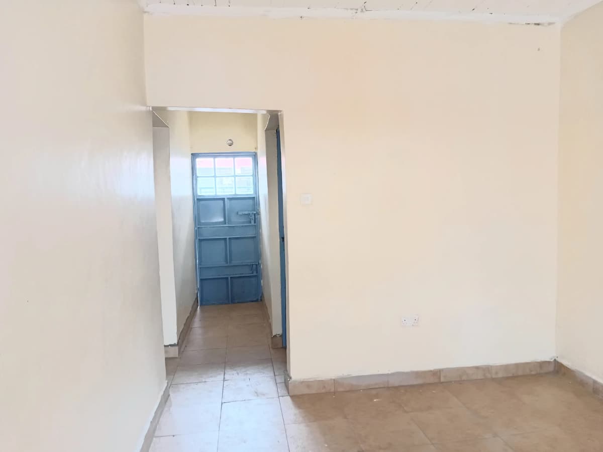 Narrow hallway with blue door leading to interior space