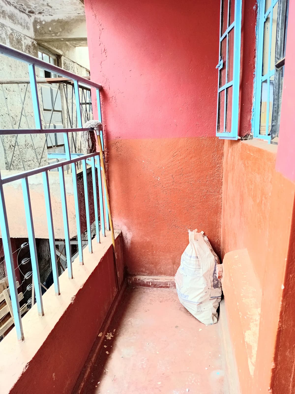 Narrow balcony with colorful painted walls and metal railing