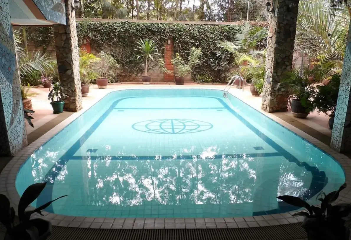 Rectangular swimming pool with decorative tile surround and landscaped garden