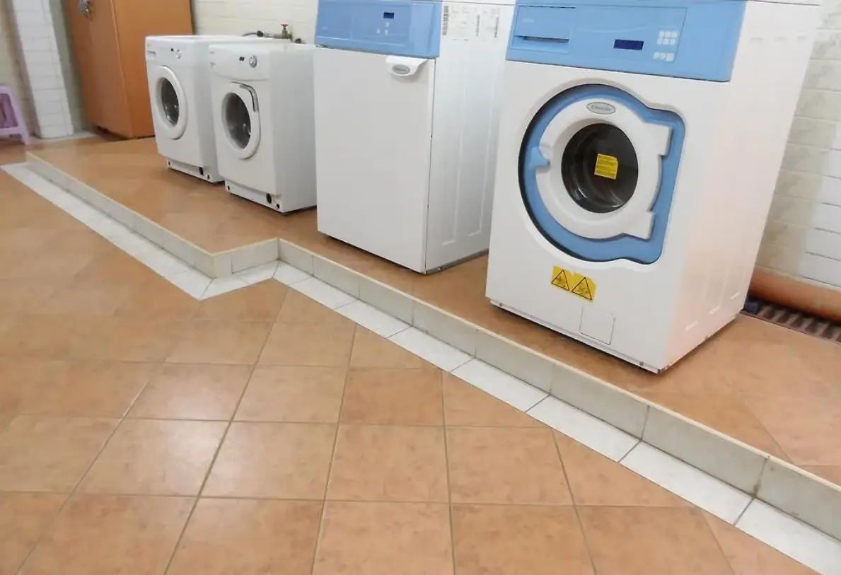 Dedicated laundry room with multiple washing machines and dryers