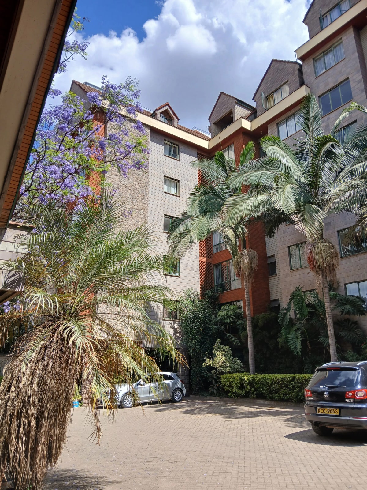 Multi-story residential building with manicured tropical landscaping