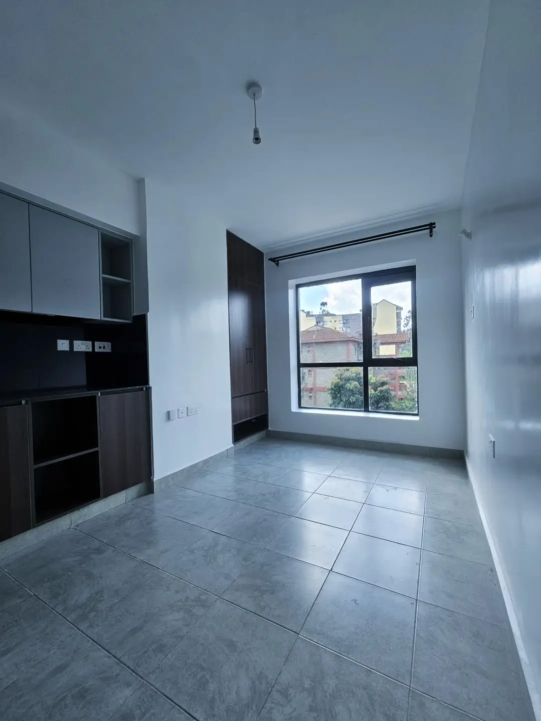 Modern kitchen with black cabinetry and large window view