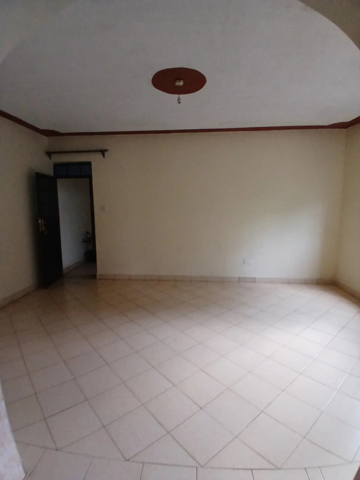 Empty living room with tiled flooring and recessed ceiling light