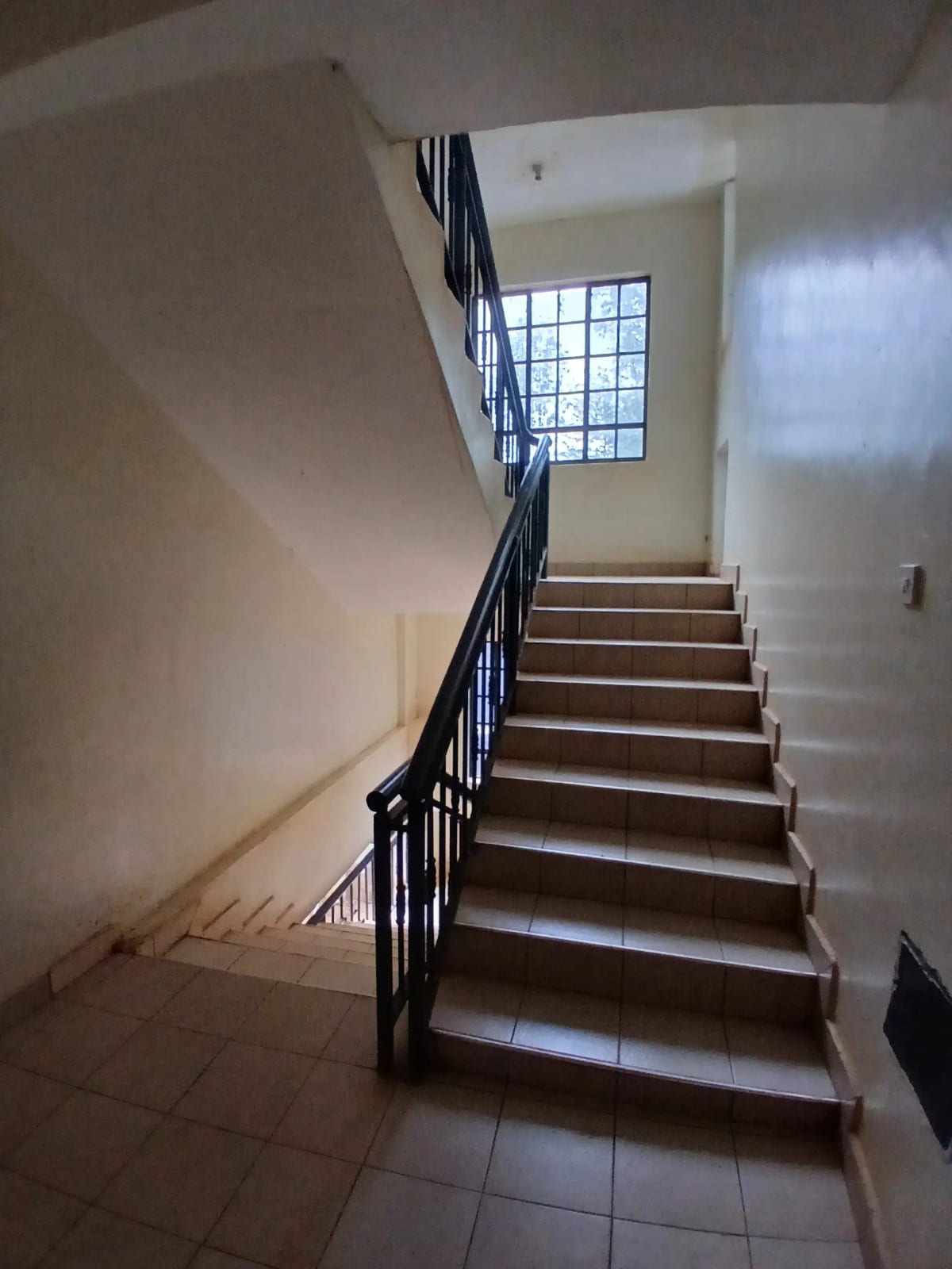 Interior staircase with metal railing and natural light