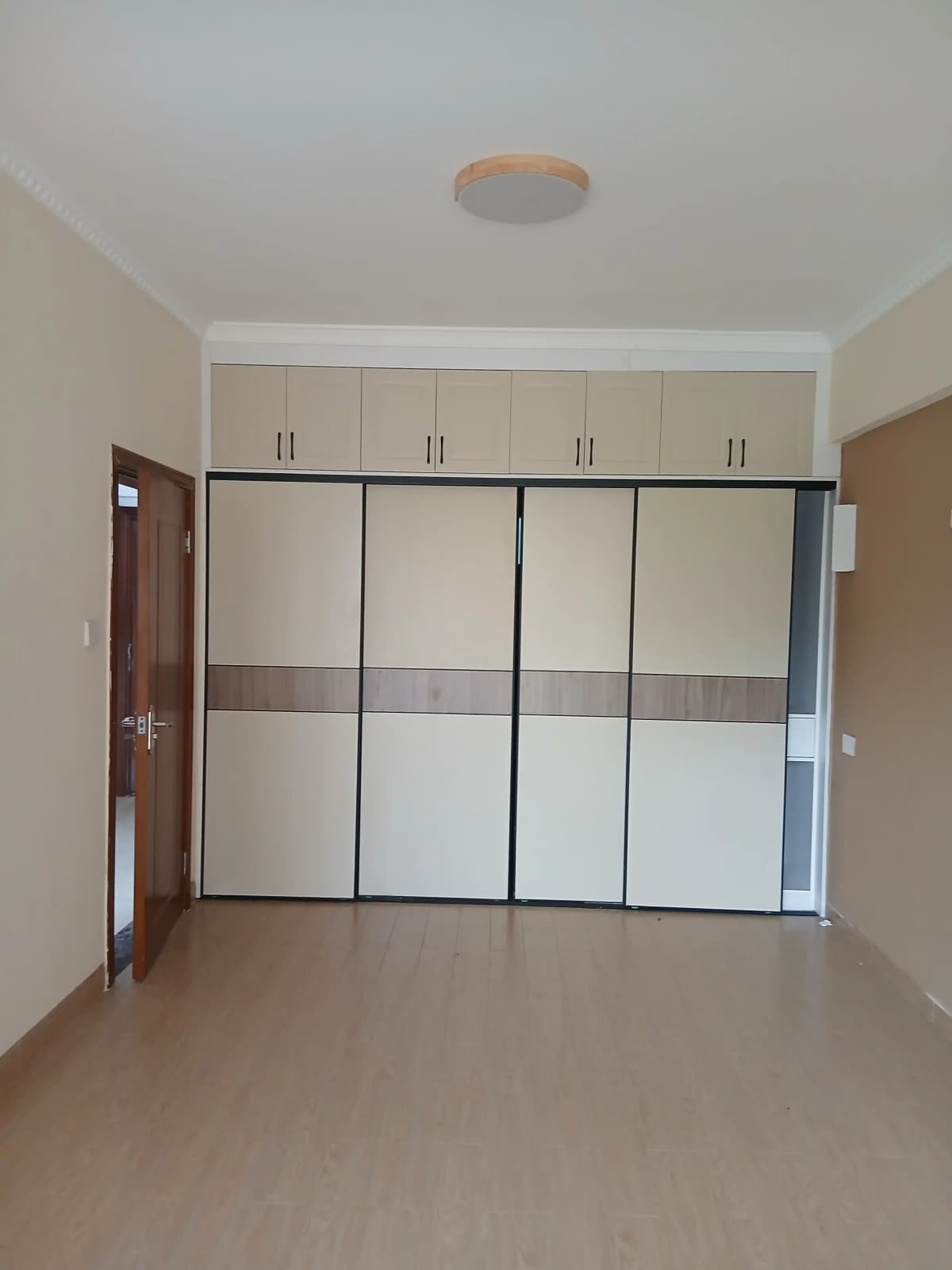 Spacious bedroom with built-in mirrored wardrobes and ceiling light