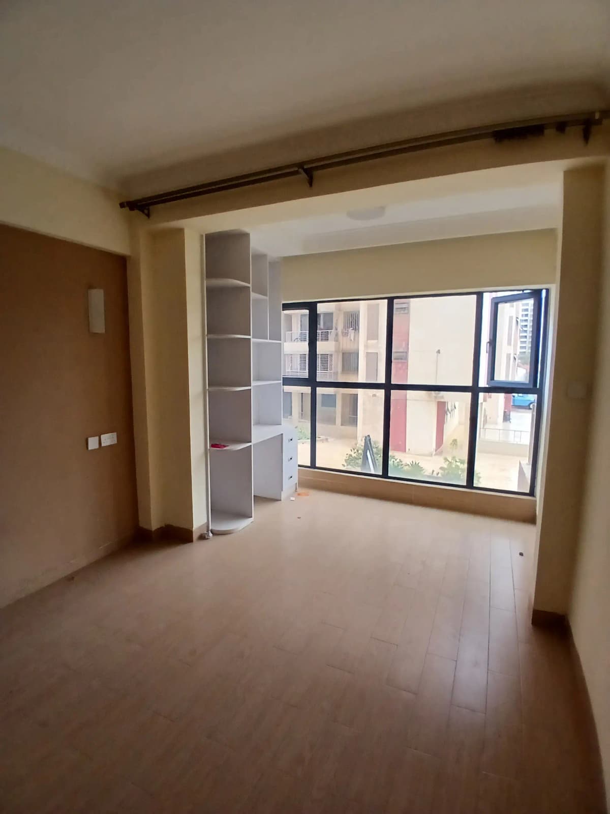 Spacious living room with large windows and built-in shelving