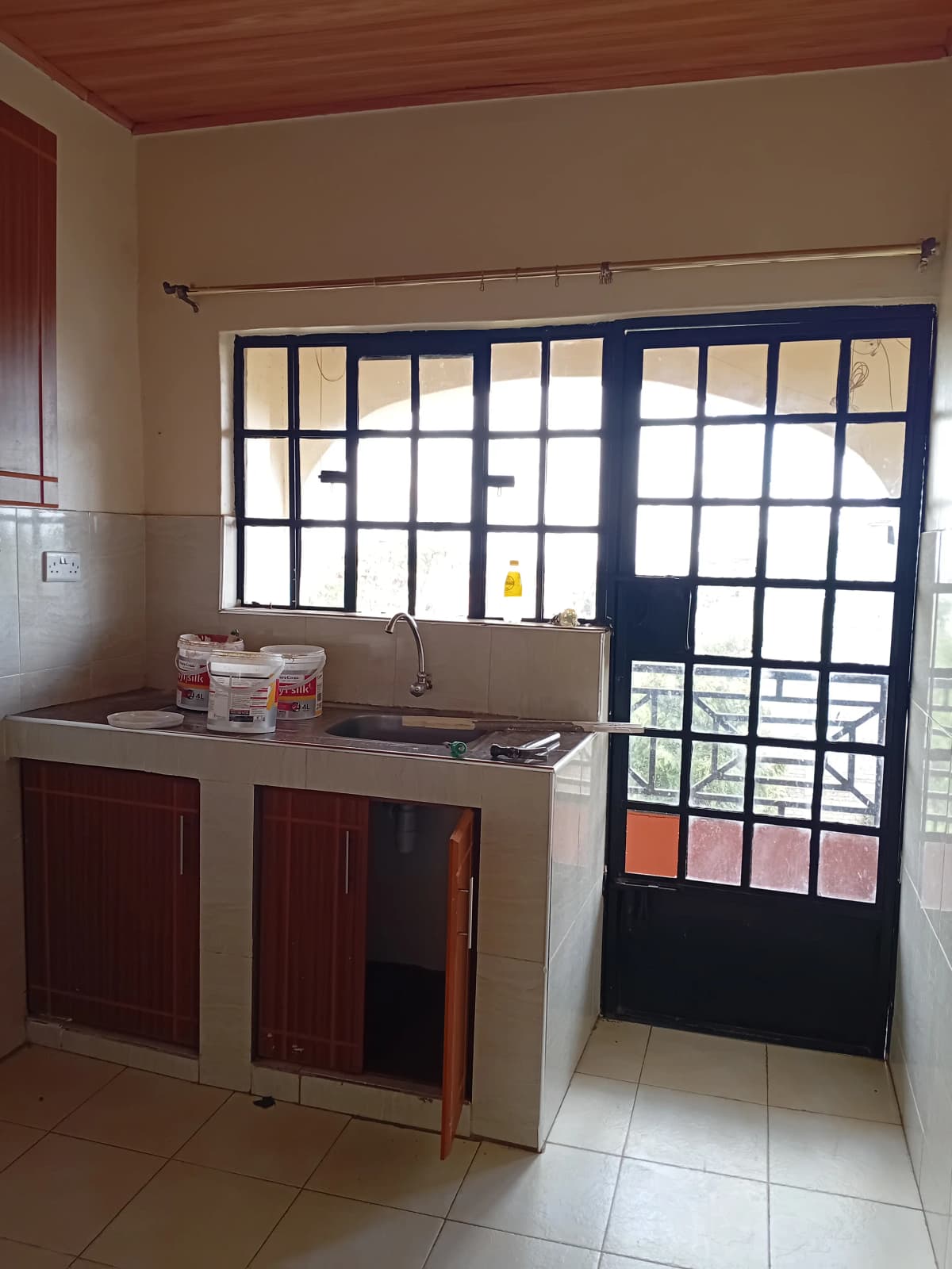 Compact kitchen with sink, cabinets, and exterior door access