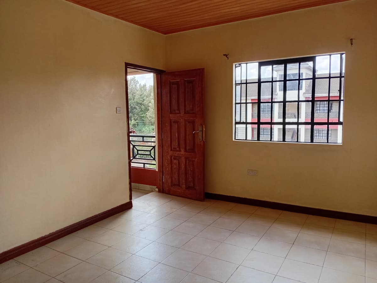 Spacious living room with wooden ceiling and barred window