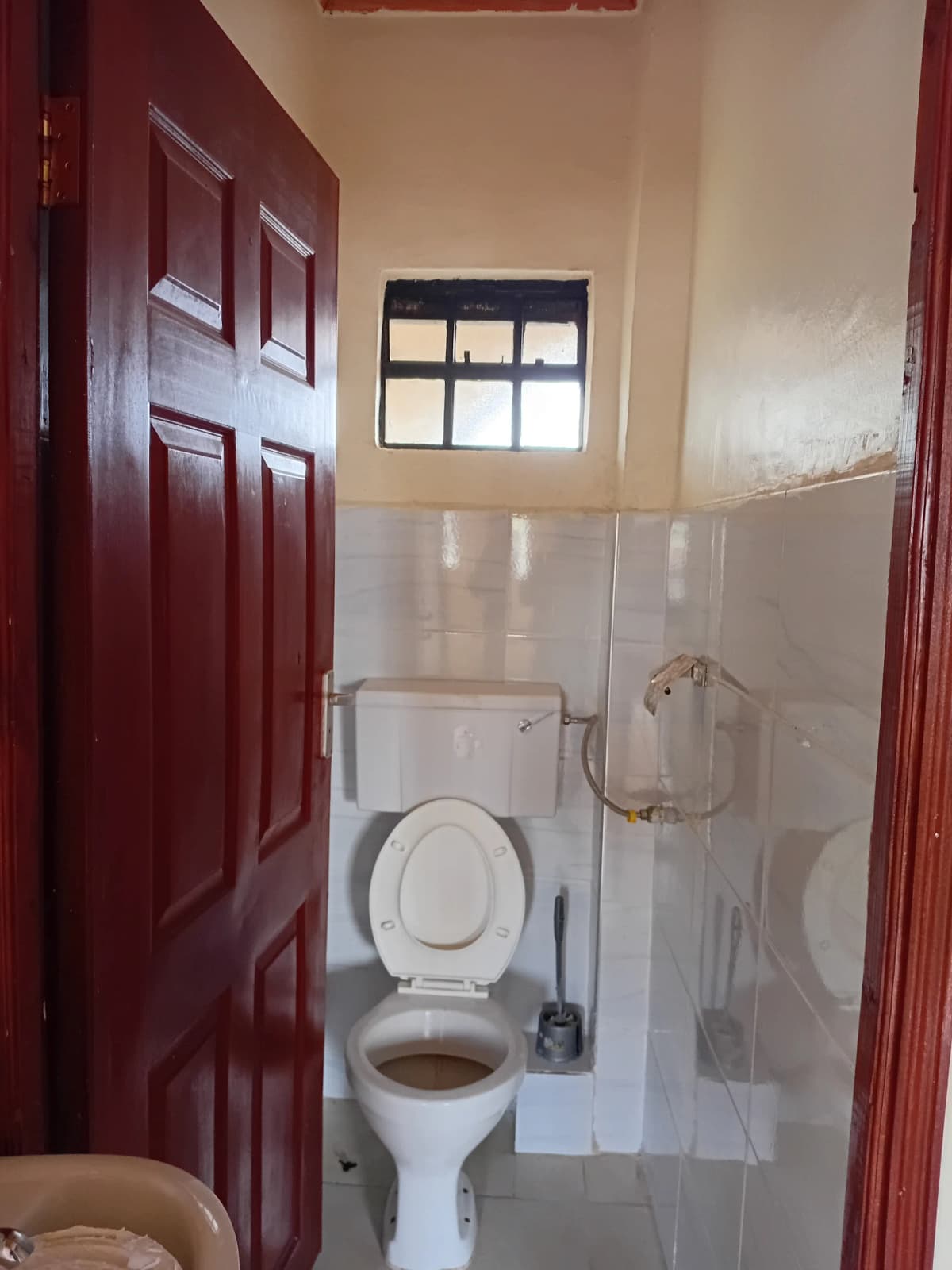 Simple bathroom with toilet, sink, and small window