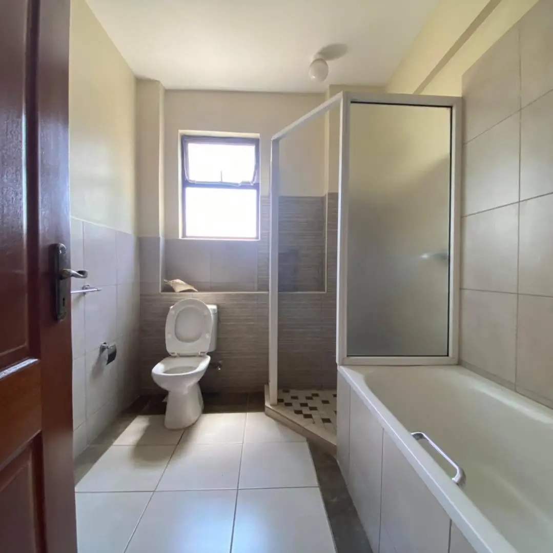 Spacious bathroom with bathtub, shower enclosure, and toilet