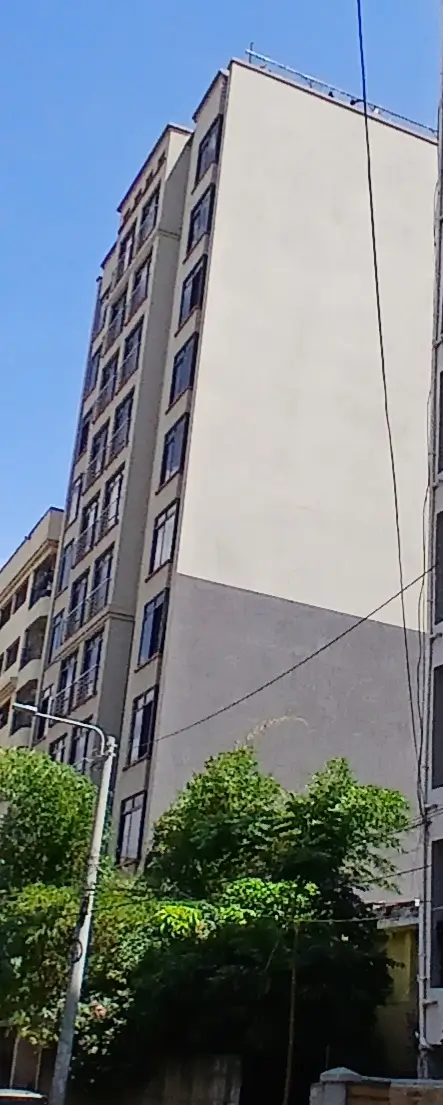 Modern multi-story residential building facade with landscaped base