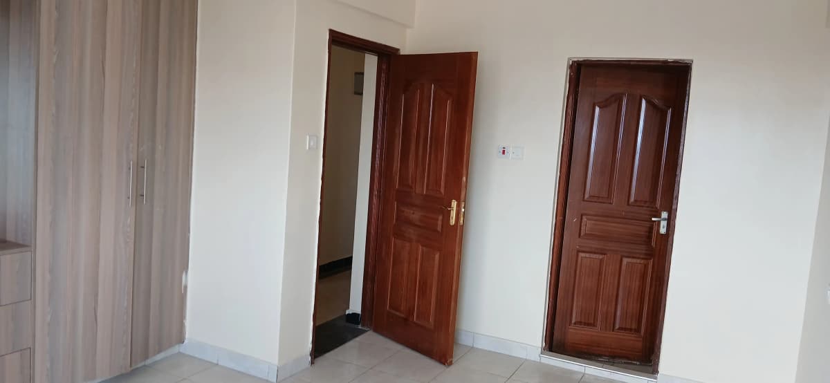Bright hallway with multiple wooden doors and white walls