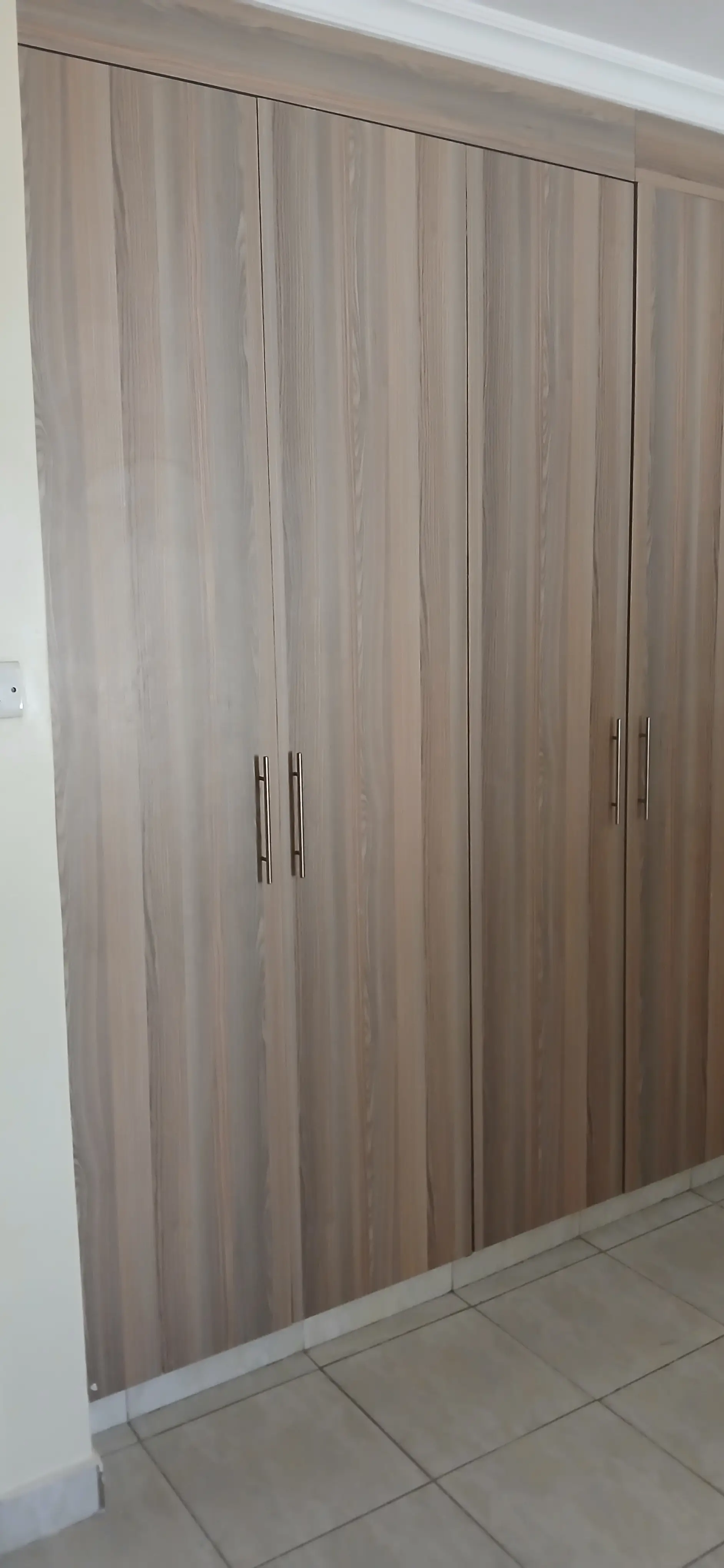 Built-in wooden wardrobe with vertical grain finish doors