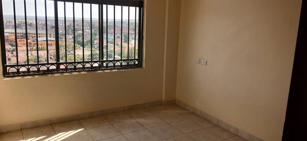 Unfurnished bedroom with barred window and city views