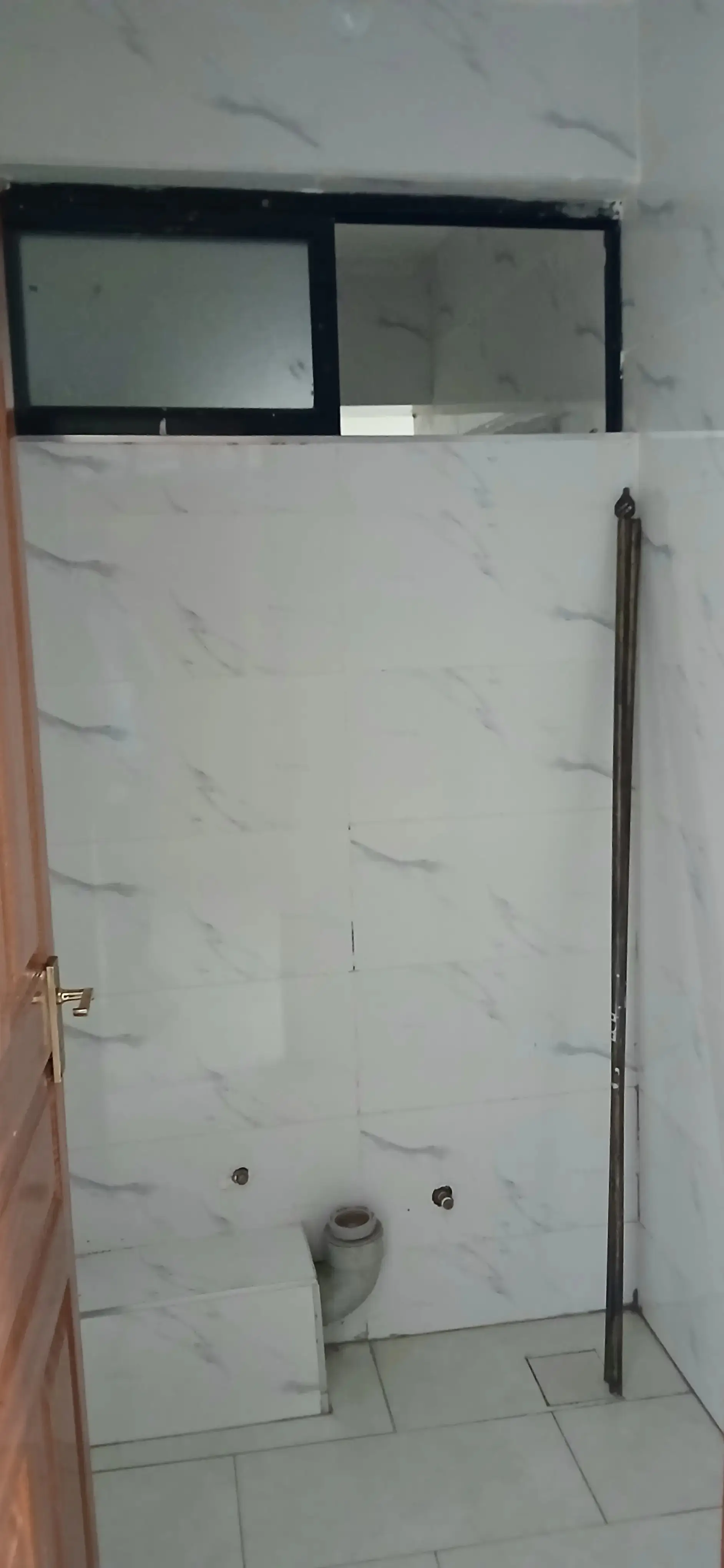 Modern bathroom with marble tile walls and glass shower enclosure