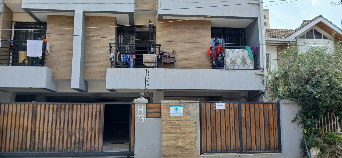 Modern two-story residential building with wooden facade and gates