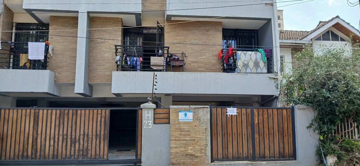 Modern two-story residential building with wooden facade and gates