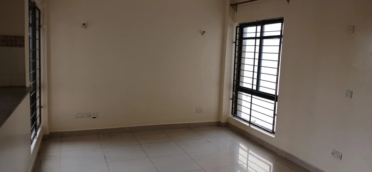 Empty living room with barred window and tiled floor