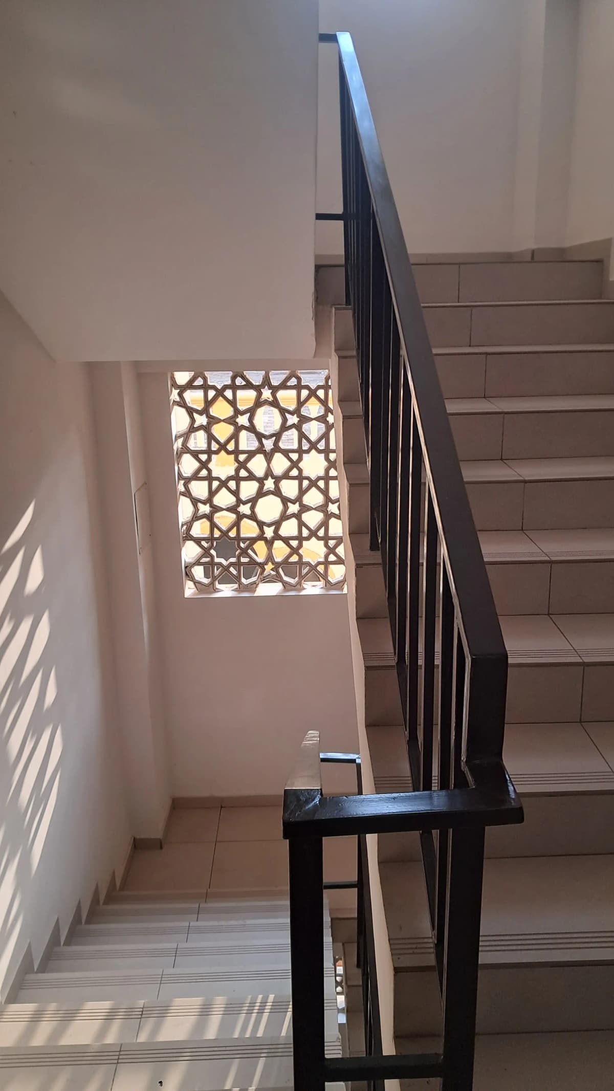 Modern stairwell with black metal railing and geometric window