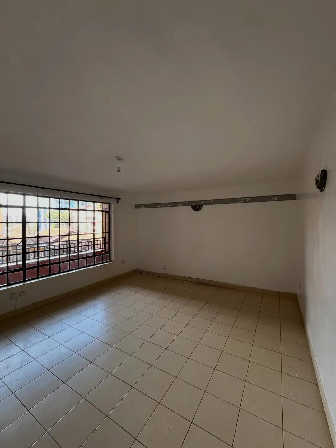 Covered balcony with tiled flooring and safety railing