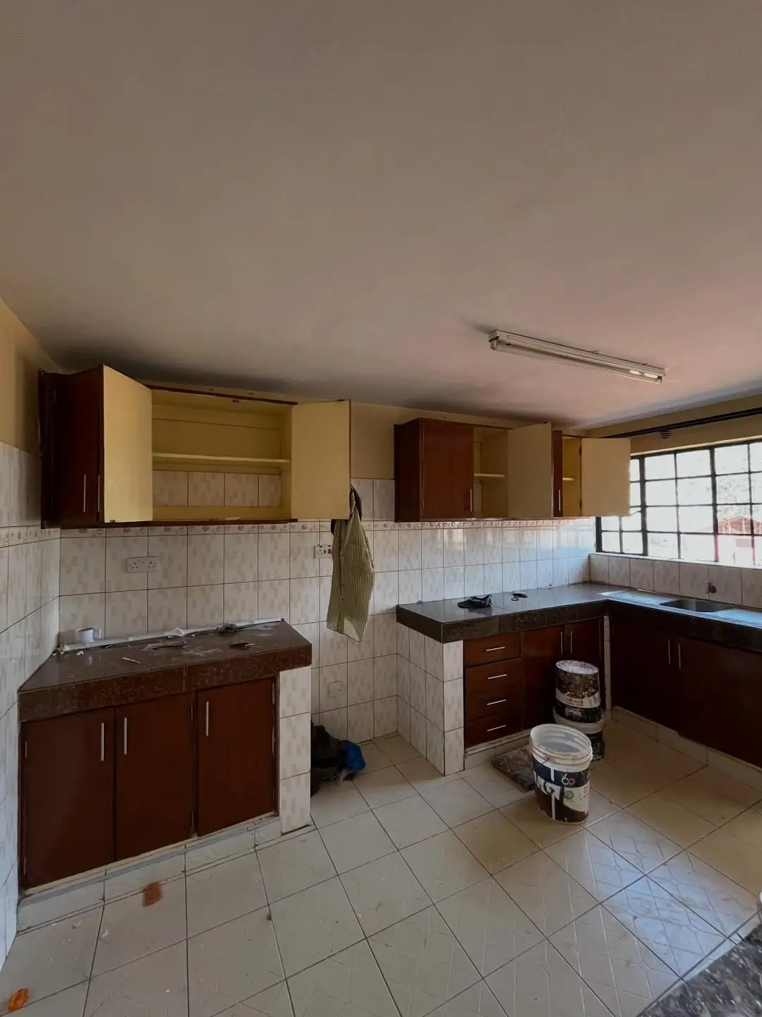 Spacious kitchen with dark wood cabinetry and tiled walls