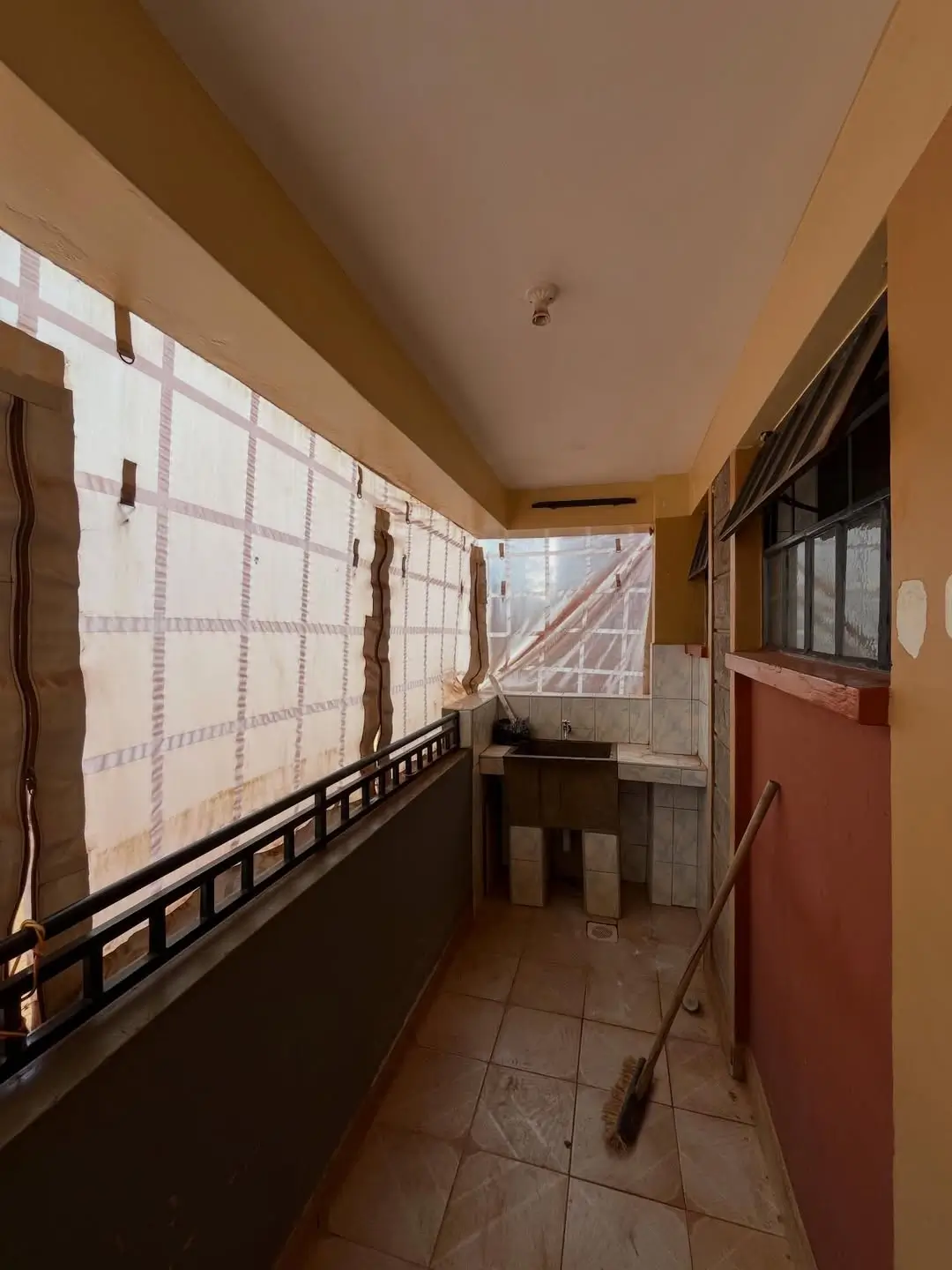 Covered balcony with large windows and city views