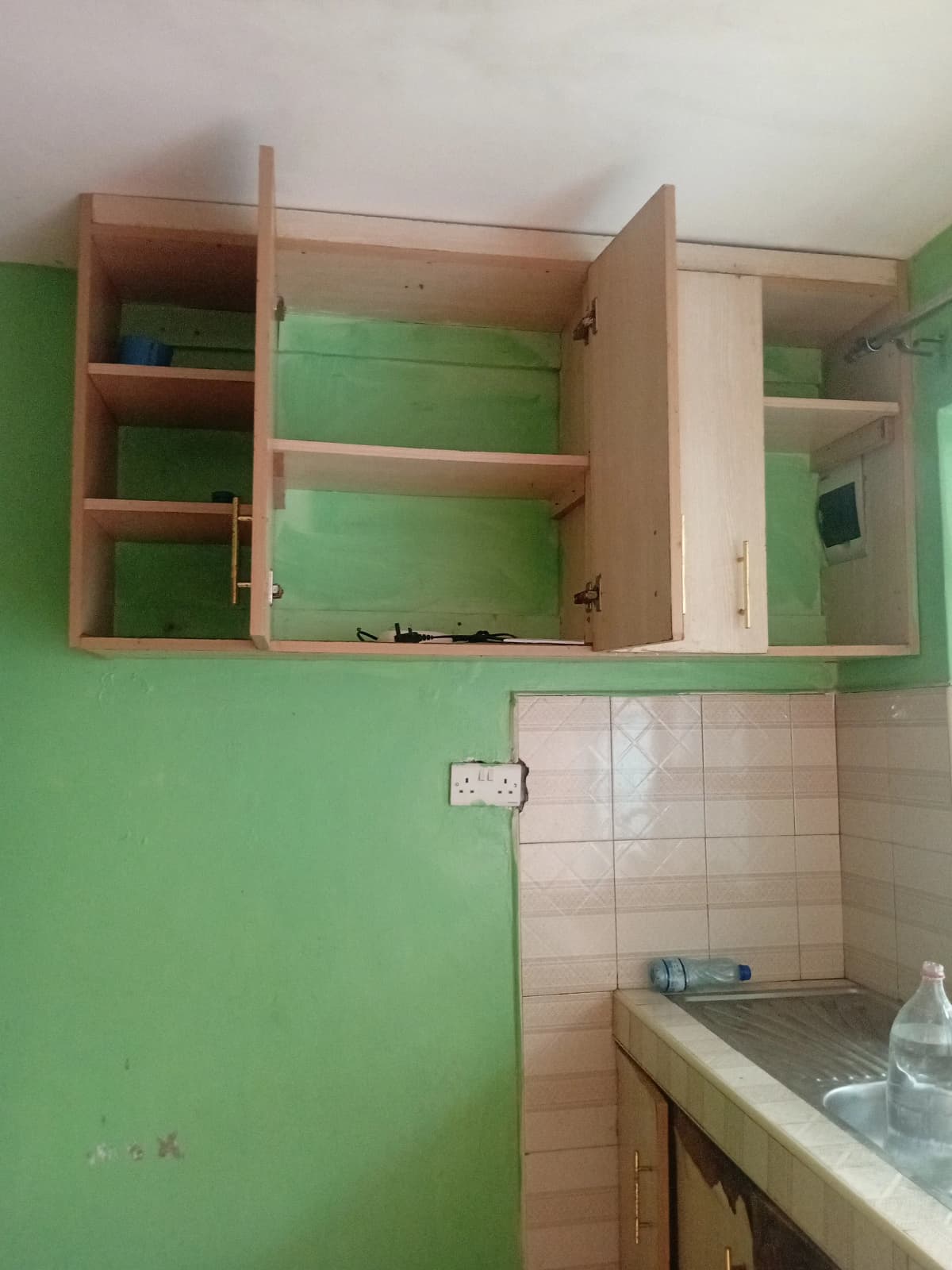 Kitchen with open wooden cabinets and sink counter