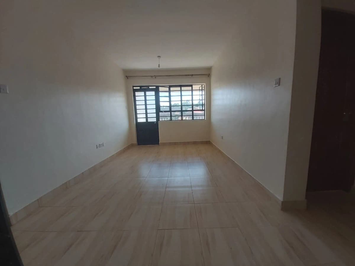 Empty living room with tiled flooring and barred window