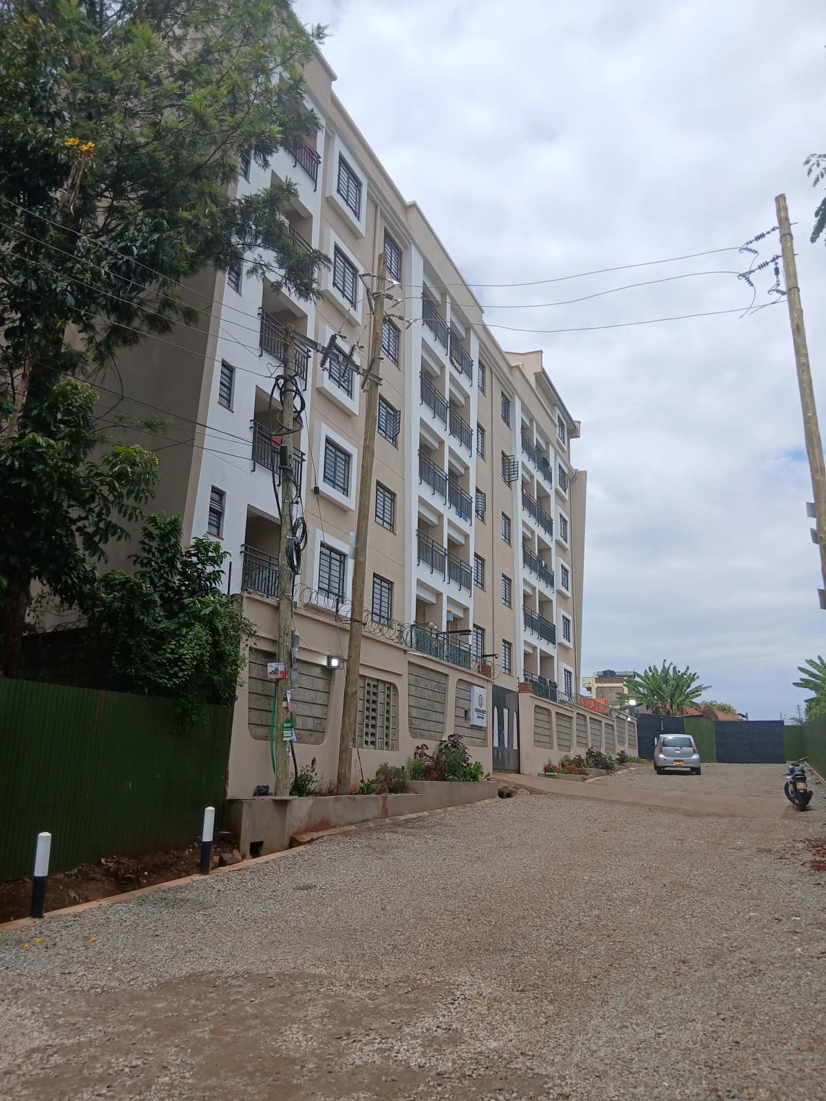 Multi-story residential building with manicured compound entrance