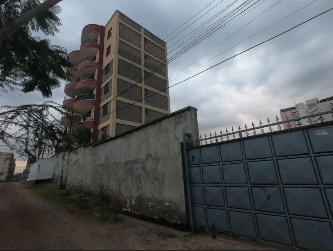 Multi-story residential building with perimeter wall and gate entrance