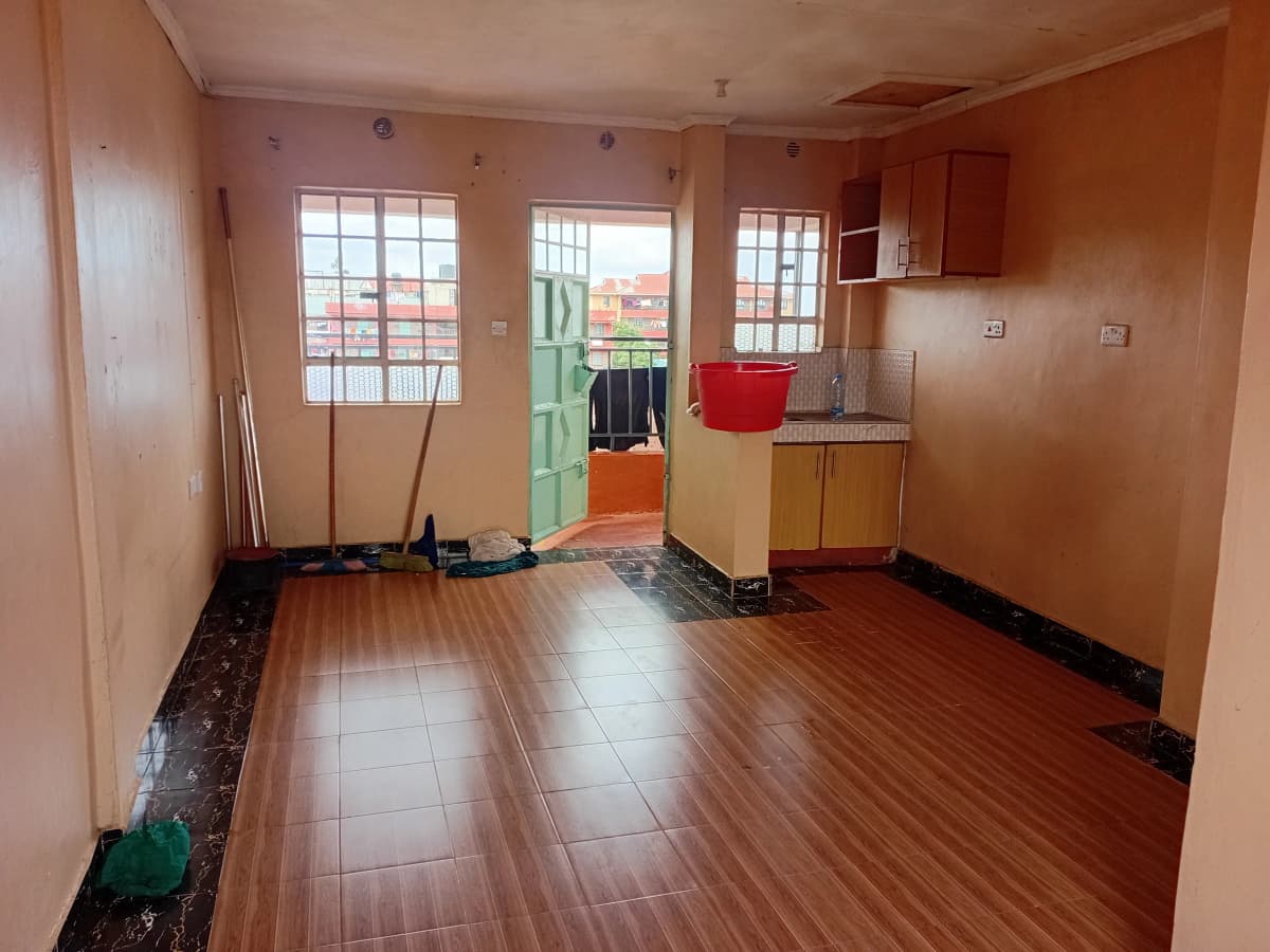 Open-plan living and kitchen area with wooden flooring