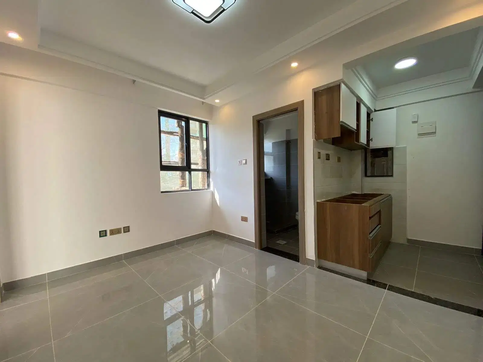 Open-plan living and kitchen area with polished grey flooring