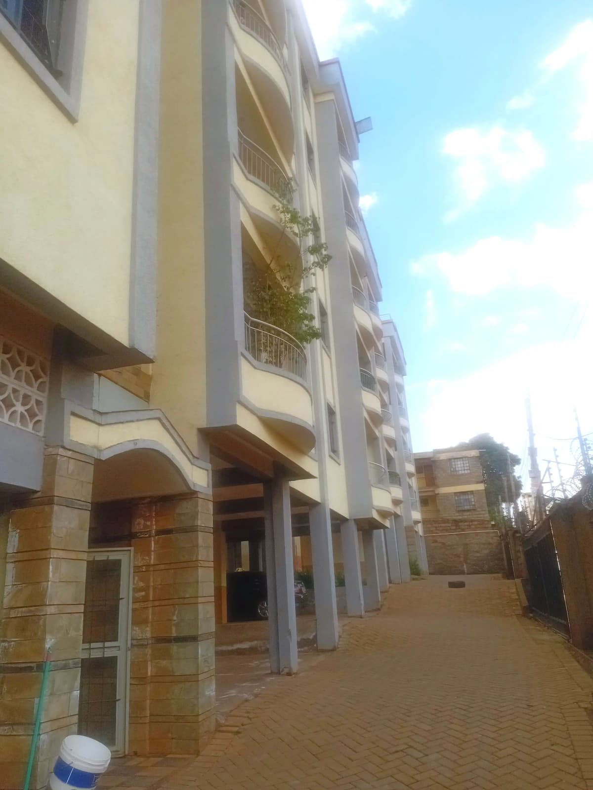 Modern multi-story residential building facade with yellow and grey finish