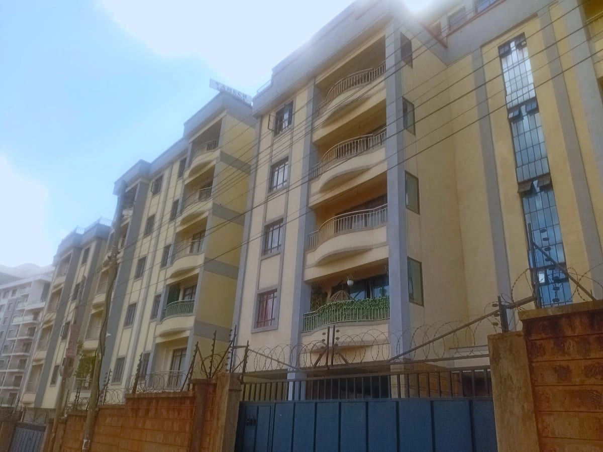 Multi-story residential building with yellow facade and balconies