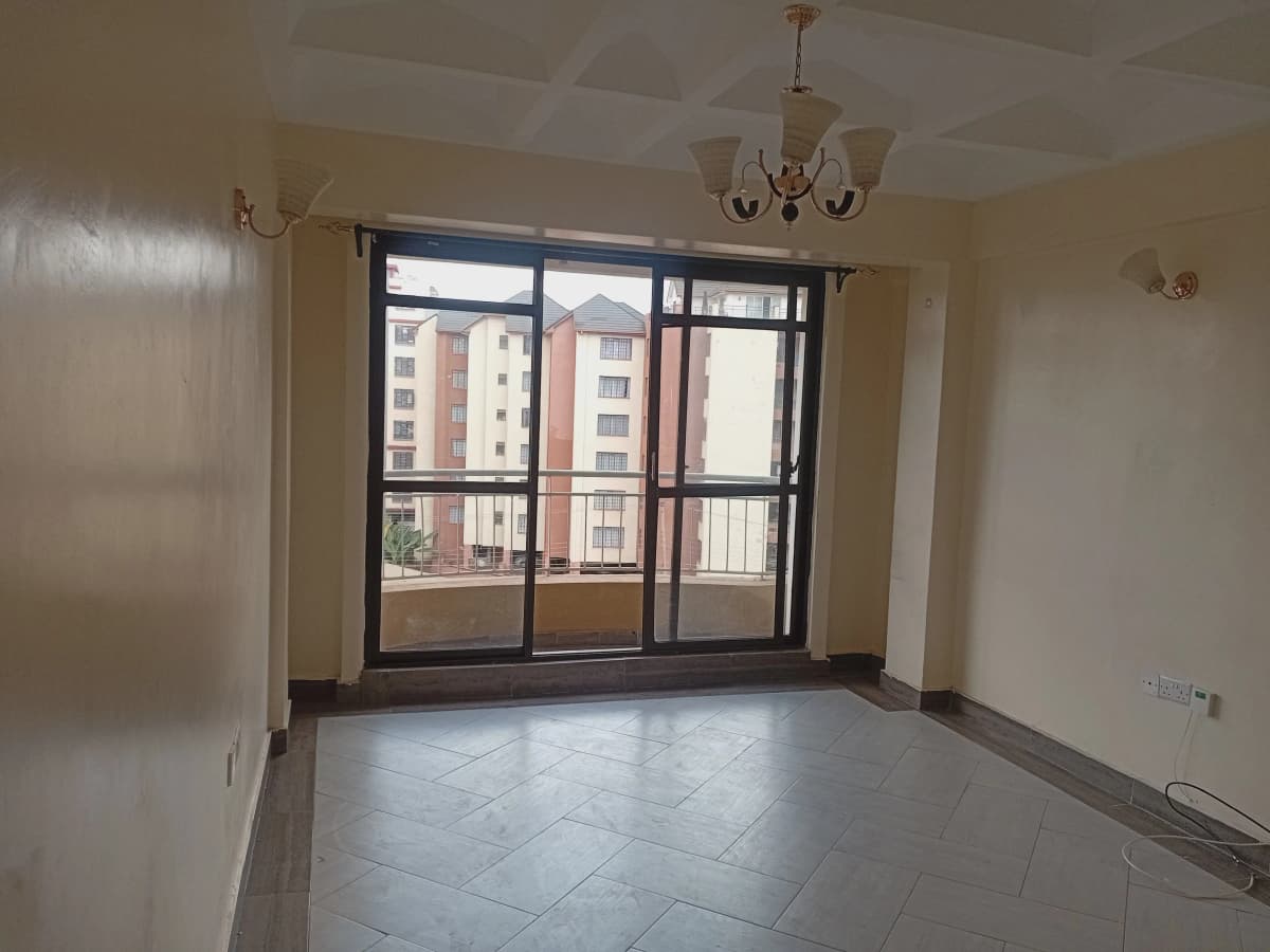 Spacious living room with large windows overlooking residential buildings