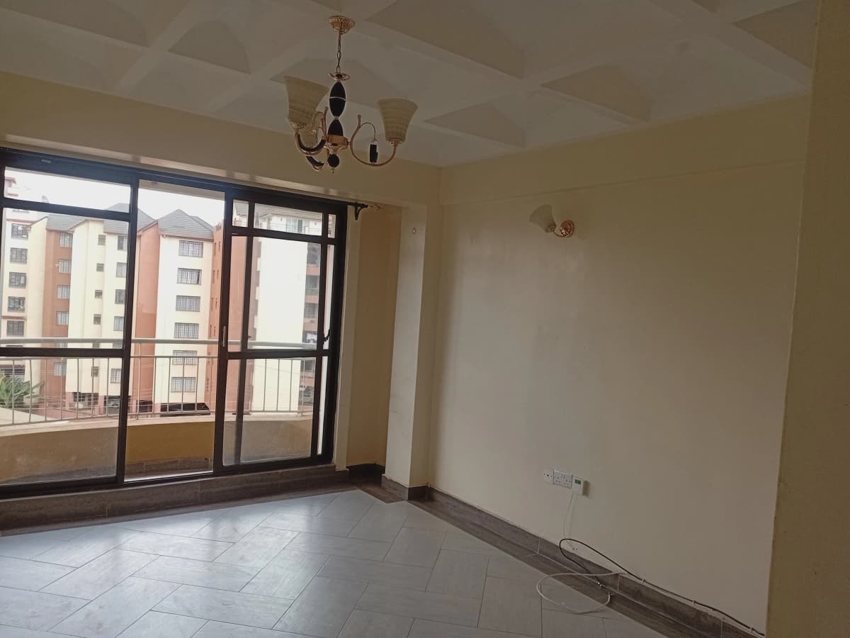 Spacious living room with large windows overlooking city blocks