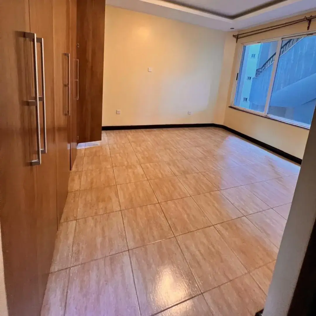 Spacious bedroom with wooden flooring and large windows