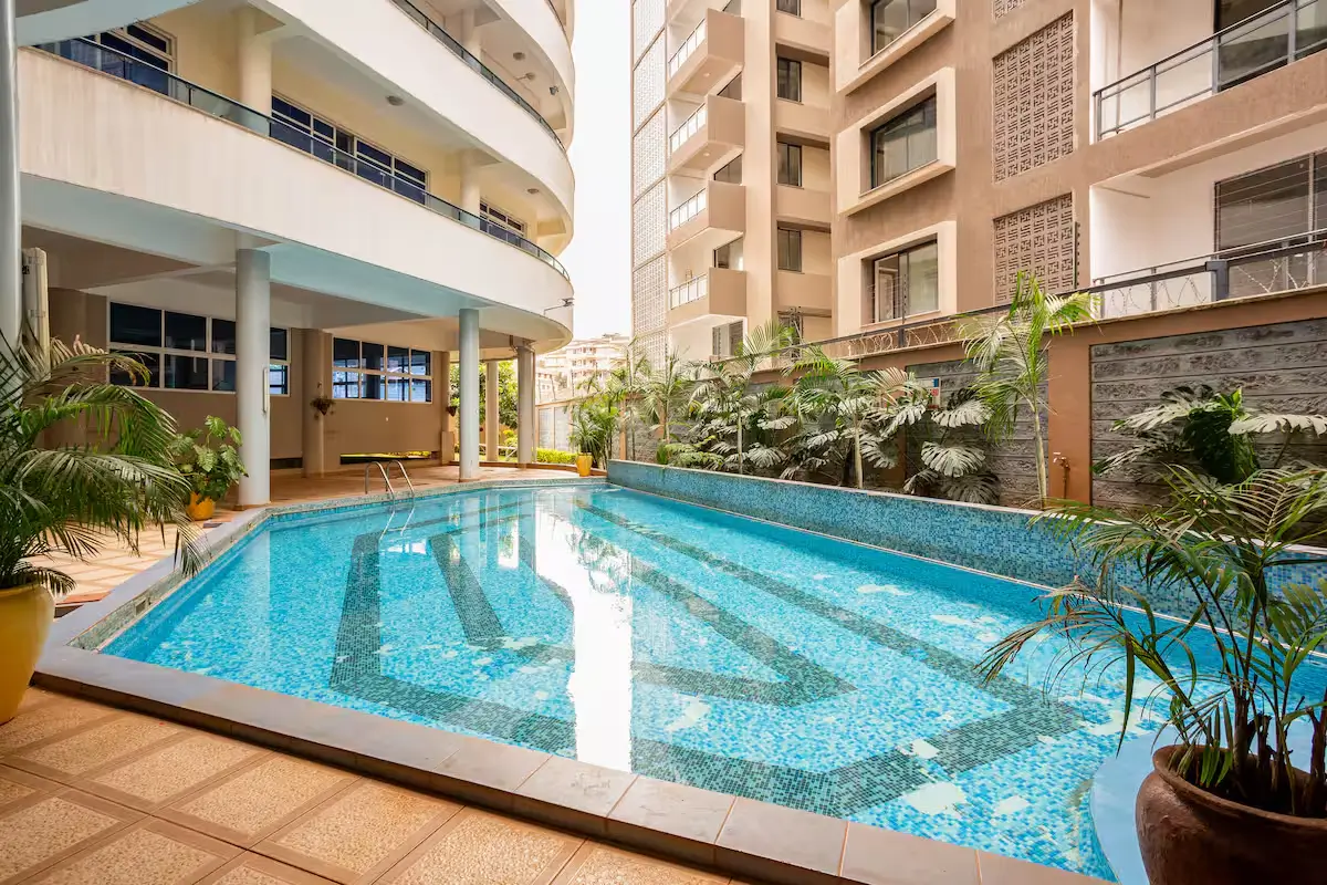 Indoor swimming pool with blue tiles and surrounding deck